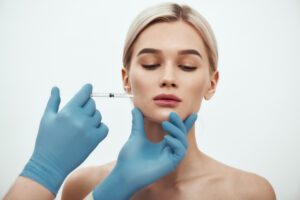 Young, beautiful woman getting preventative Botox injections in her jaw to mitigate wrinkles
