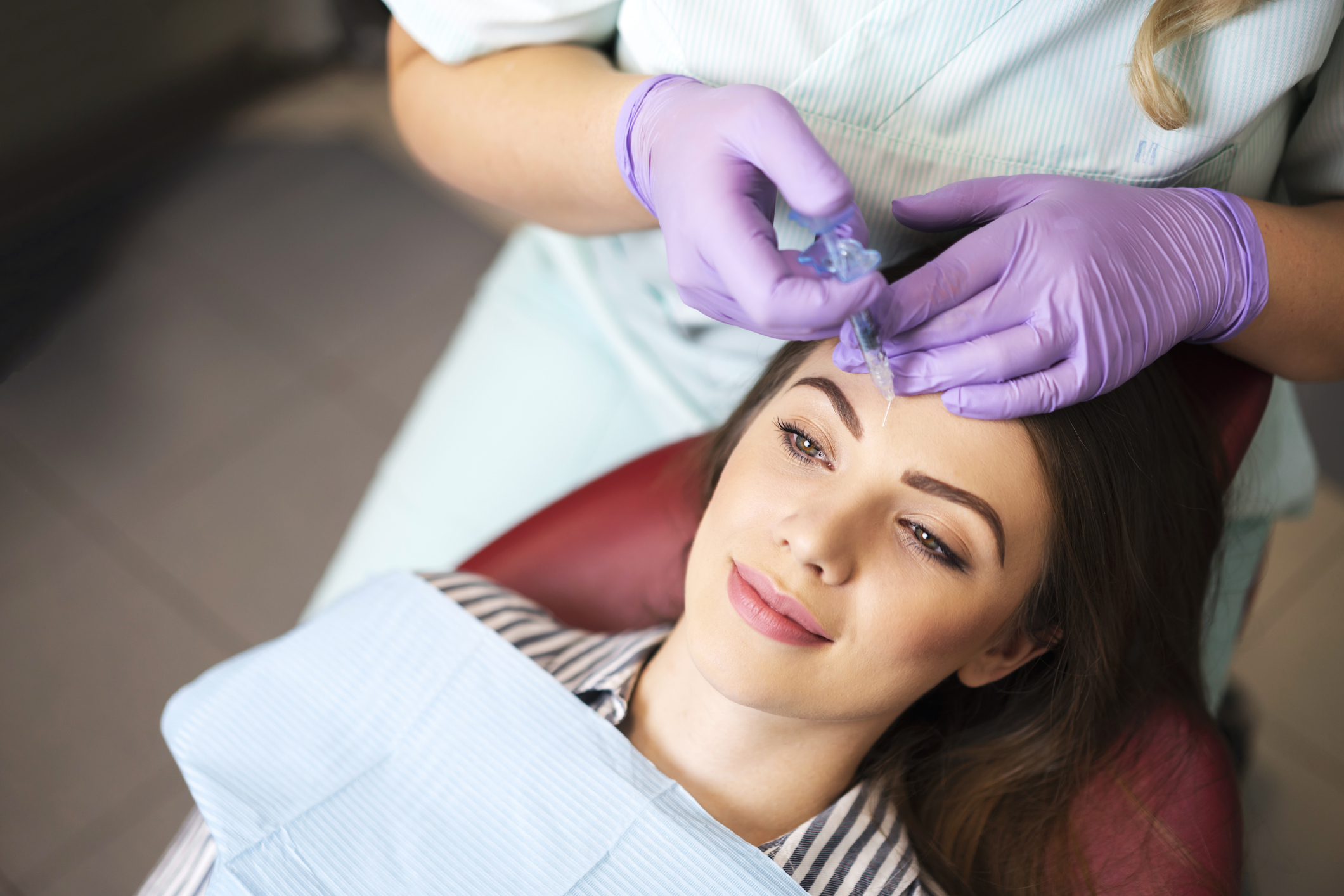 Young woman on a beauty treatment with the filler injection at the beauty clinic.